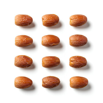 Closeup of a collection of dates arranged on a white surface.