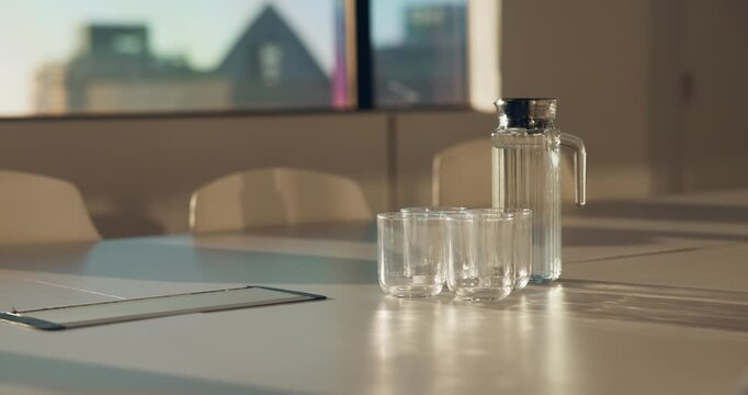 Meeting, glass and water on tablet in empty office for workshop, corporate and boardroom. Planning, conference and furniture with h2o drink on desk of interior room for seminar and workspace