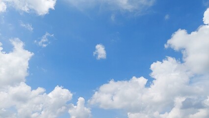Fototapeta premium Panoramic clear blue sky background with peaceful white cloud formations. Beautiful summer landscape with bright blue colors and soft fluffy clouds in the sunny sky.