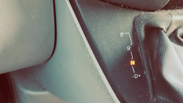 Ein Mann bedient das Automatikgetriebe von seinem Auto