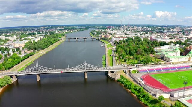 Panorama of the city of Tver, Russia. Aerial sweep over the Volga River revealing the ornate ironwork of Starovolzhsky Bridge and the historic Novovolzhsky Bridge beyond.. Drone footage