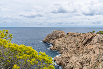 Scenic view of the rocky Costa Brava coastline in Catalonia, Spain on a cloudy day. Rugged cliffs meet the blue sea, forming a dramatic seascape that attracts visitors and sen. © Ilja
