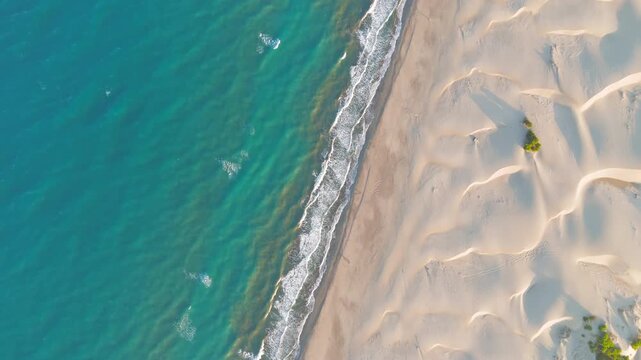 Gelemis, Turkey. Top down aerial view of Mediterranean Sea waves on Patara Beach, blue water, white foam and yellow sand with sea turtle tracks. Aerial View