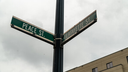Fototapeta premium Peace Street and Lafayette Street Intersection Signs Against Cloudy Sky, Trenton New Jersey