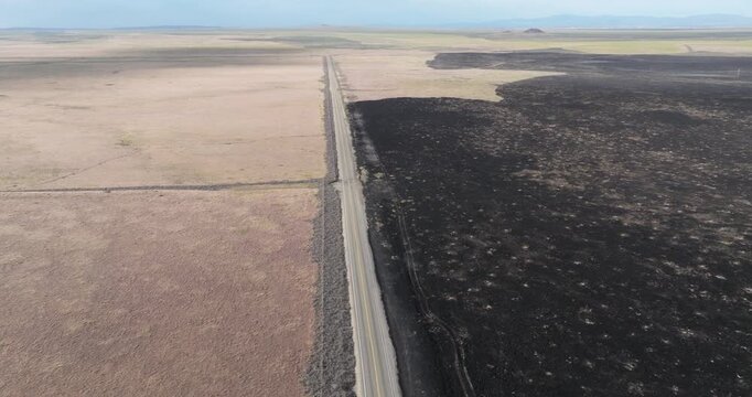 High angle shot of a straight road dividing two landscapes
