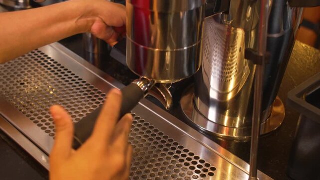 Action Shot of Barista Preparing Espresso Brew by Attaching Portafilter to Professional Machine