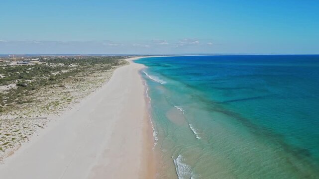 Idyllic Atlantic coastline near Comporta and Lisbon, Portugal, featuring clear turquoise water, pristine sandy beach and seaside scenery, aerial view