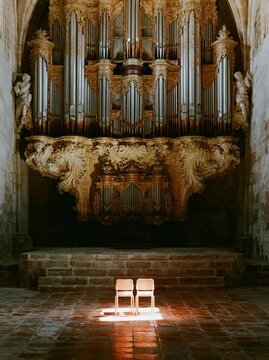 Massive baroque pipe organ with ornate wooden carvings in a historic church interior for classical music promotion, religious heritage sites and architectural