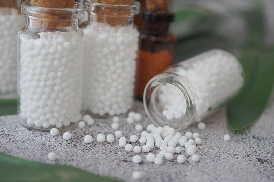 homeopathic globules in glass jars on a table