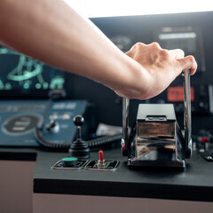 Captain hand holding throttle control or engine control lever on boat dashboard with GPS navigation and marine radar in wheelhouse or ship bridge. Speed adjustment instrument for seafaring technology © zephyr_p
