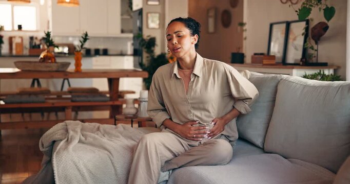 Woman, stomach ache and sofa with pain in home for indigestion, diarrhea or gastrointestinal reflux. Frustrated, female person or menstrual cycle with sore cramps for viral infection or constipation