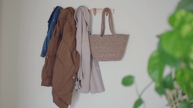 Jackets and a bag hanging on a wall in a home