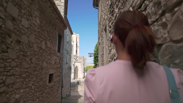 Woman walking through the narrow medieval streets of Girona