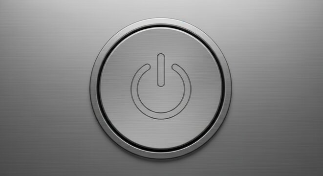A close up view of a modern circular power button on a metallic surface.