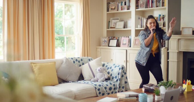 Singing, dance and woman with remote in home for good mood, positive energy and karaoke. Happy, living room and person with lyrics for music, audio and playlist for groove, dancing and fun on weekend