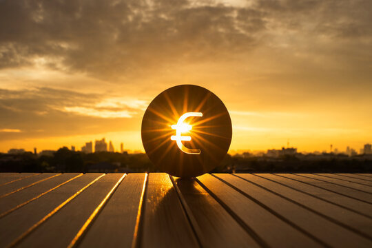 Euro currency symbol with bright sun shining through against a golden sunset city skyline background. Concept of European financial market growth, global economic success, and investment future.