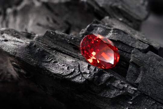Red Ruby gemstone on black coal background, close up shot