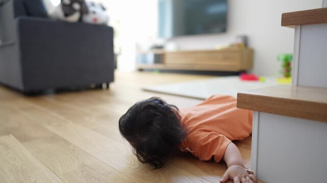 Tiny toddler crawls across hardwood floor. Child's face shows pure, unfiltered joy. Baby laughs as they explore their world. Climb through furniture with curious delight. Perfect for baby development