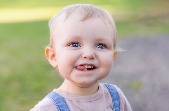 Portrait of a cute toddler laughing and showing tongue.