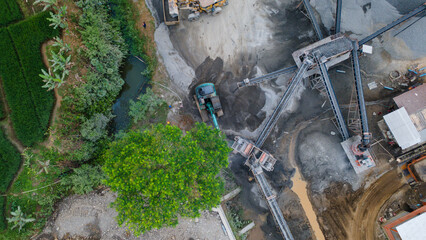 Mining Work in Quarry Industrial Site, Excavator and Wheel Dozer near Rock Crusher Facility from Above © katakaneh
