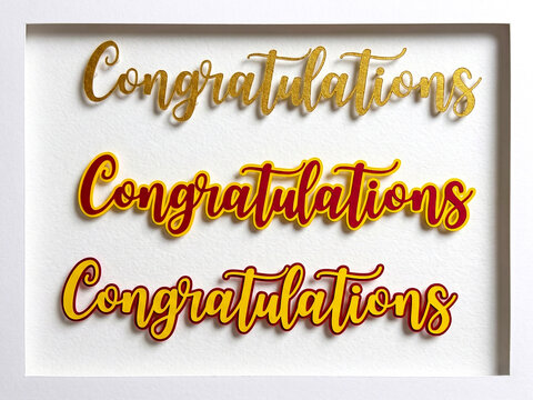 "Congratulations" typography layered in 3D paper-cut style (gold, red, yellow) within a white shadow box.