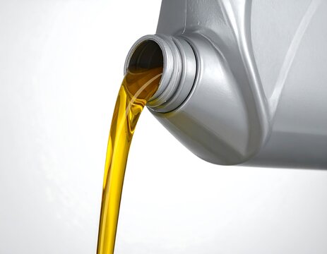 Close-up of a container pouring yellow liquid onto a white background, highlighting the flow and color contrast
