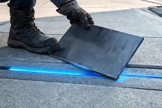 Worker placing stone slab with blue neon light