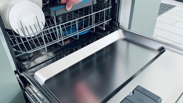 Ceramic plates arranged on upper dishwasher rack showing clean dishware organization and design