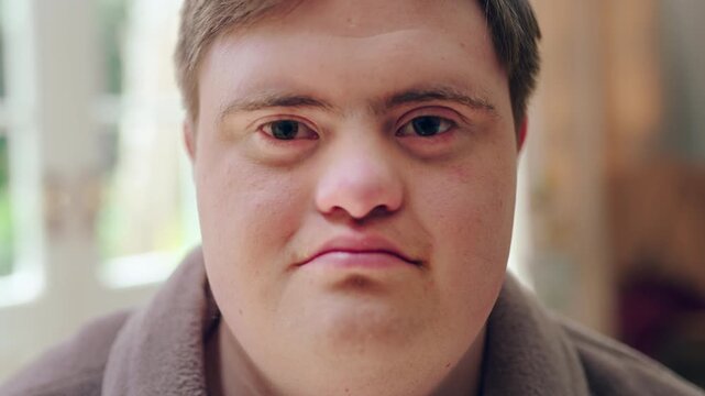 Face, relax and man with down syndrome in living room, morning peace and staycation for weekend break. Calm expression, chilling and male person with portrait in apartment, home and rest for day off