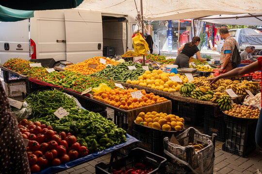 A vibrant commercial display of colorful fruits and vegetables under umbrellas at a traditional Turkish bazaar.