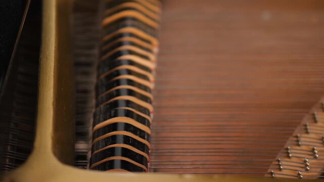 Macro shot of piano internal mechanism with moving hammers. Detailed view of a keyboard instrument working during musical performance.