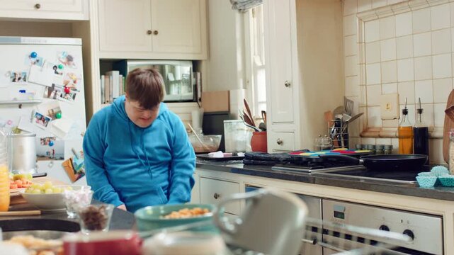 Home, dancing and man with spoon in kitchen, weekend karaoke and practice trick for entertainment. Singing, utensil and male person with down syndrome in apartment, groove and moving to music beat