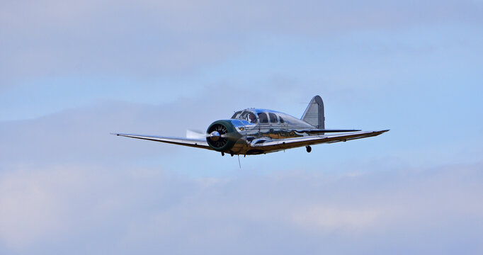 Vintage Spartan 7W Executive aircraft in fligh colourful clouds