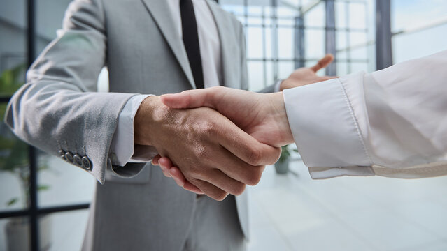 Two professionals shake hands in a modern office