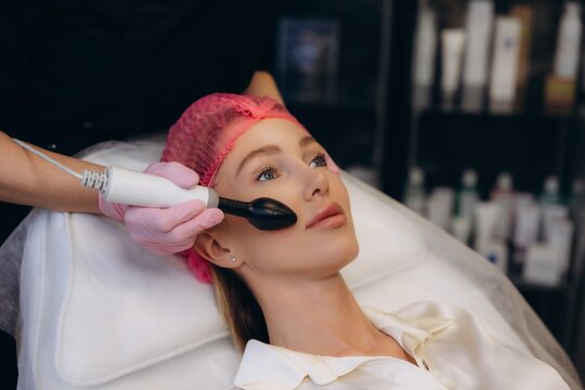 Woman receiving microcurrent facial treatment for skin rejuvenation