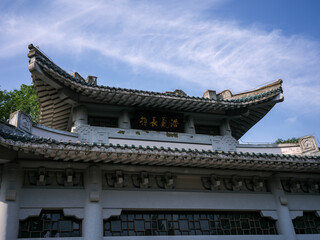 Fototapeta premium Close up of traditional white Chinese building roof and plaque under blue sky