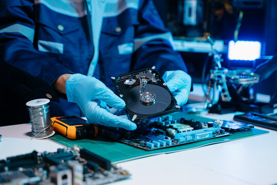 Technician repairing inside of hard disk drive by screwdriver. the concept of data, hardware, technician and technology. computer hardware, repairing, upgrade