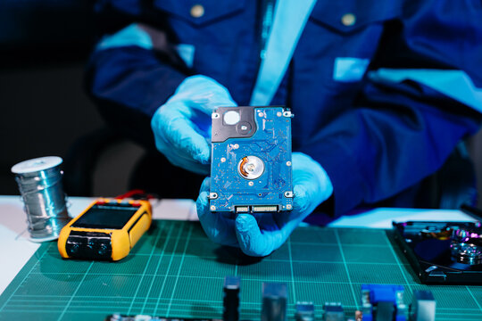 Technician repairing inside of hard disk drive by screwdriver. the concept of data, hardware, technician and technology. computer hardware, repairing, upgrade