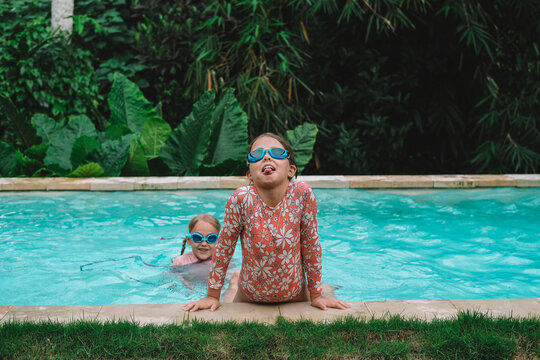 Child in swimming pool, happy summer lifestyle with water play, sunshine, relaxation and bright family vacation energy in a clean outdoor setting, soft natural light, realistic detail, clean