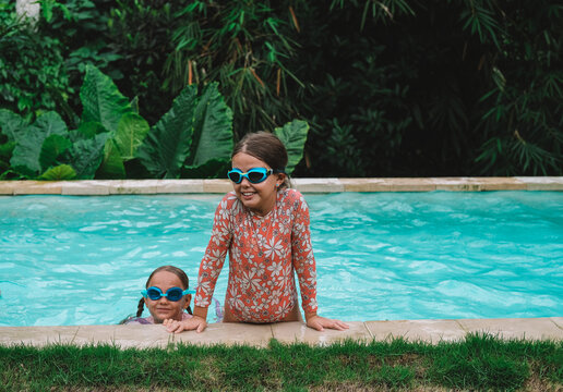 Child in swimming pool, happy summer lifestyle with water play, sunshine, relaxation and bright family vacation energy in a clean outdoor setting, soft natural light, realistic detail, clean