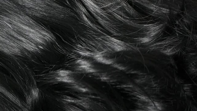 Closeup beautiful female black long curly hair texture background in slow motion
