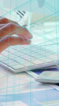 Vertical video: Hand nearing keyboard, other hand joining, hands typing data for analysis teal grid
