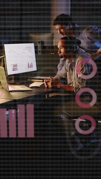 Vertical video: Man on call, peer leaning pointing adding data charts and CSV on screen for review