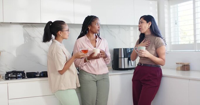 Women listening as right woman starting to speak, gesturing and reassuring in kitchen holding mugs
