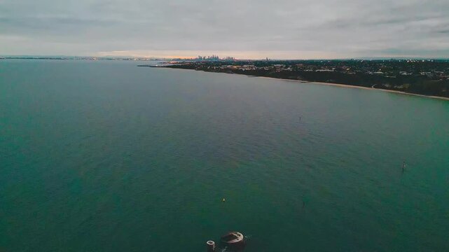 Aerial drone footage showcasing HMVS Cerberus resting off Half Moon Bay surrounded by calm ocean waters and scenic coastal landscapes.