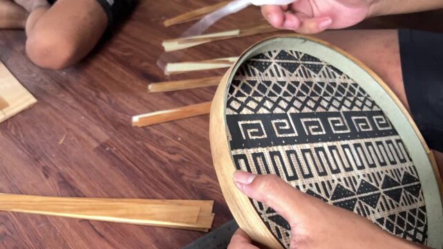 4K static handheld editorial broll of artisan hands applying glue to thin wood veneer on a handmade tray Woodworking craftsmanship process creating premium wooden home decor in a creative workshop