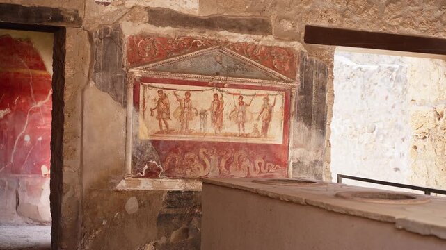 Painted fresco and serving counter inside a Pompeii thermopolium, showing red Roman wall art, dolia openings, and preserved ancient food shop details.
