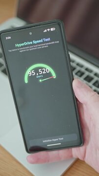 Hand holding smartphone displaying futuristic cellular speed test application UI