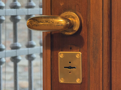 Close Up of Vintage Brass Door Handle and Keyhole on Wood