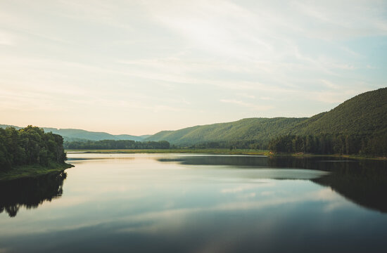 Quiet lake reflects the rolling green hills